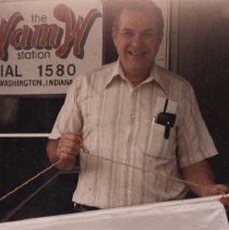 Bill Greene holding a WAMW banner (ca. 1985-1990)