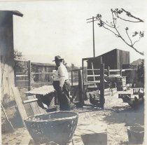 Charles Rehrman feeding chickens at 131 W Palm