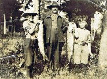 Man and two boys with two large fish