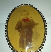 Young child photo in oval metal frame