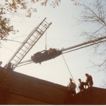 Fire fighters on top of a building with ladder and pulley