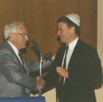 Mendel Piser handing gavel to Alan Feldbaum
