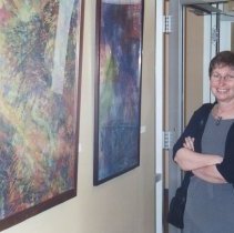 Woman next to paintings