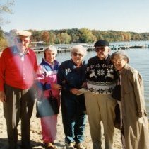 Five people standing on beach