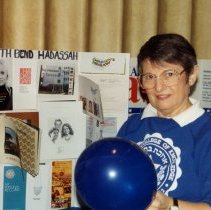 Woman standing in front of Hadassah poster with bowling ball