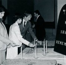People lighting candles at Holocaust program