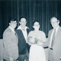 Foru people posing with silver plate award
