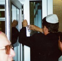 Mezuzah being placed on Federation building at dedication