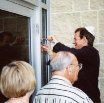 Mezuzah being affixed to Federation building at dedication