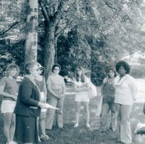 Shirley Natkow speaking to eight women at water's edge
