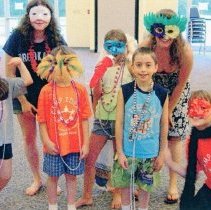 Campers and counselor dressed in masks and beads