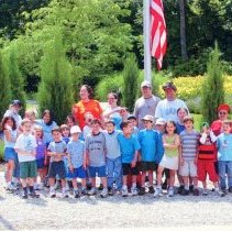Campes and Counselors Standing in Front of Flagpole