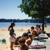 Campers sitting on picnic table in front of counselors.