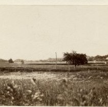 Reservoir with field and small building in background