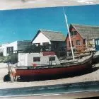 La embarcación Ana Carolina y los ranchos atrás.