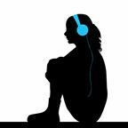 A teen wearing headphones while sitting on the floor.