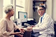 Health care provider speaking with a patient in the provider's office.