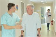 A health care provider talking to and assisting a person in a health care facility.