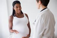 A pregnant adult talking to a health care provider. 