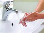 Washing hands with soap and water at sink.
