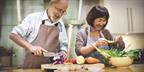 Two people preparing food together in the kitchen.