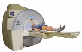 An MRI machine with a person lying on the table that slides into the machine.