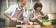 Two people preparing food together in the kitchen.