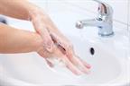 A person washing hands with soap and water in a sink. 