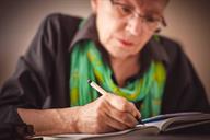 Person sitting at a desk and writing in a notebook.