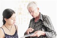 A health care provider showing a teen an X-ray on a computer tablet.