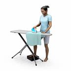 A person standing and ironing with one foot resting on a stable footstool to help keep the spine neutral.