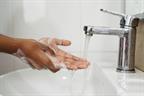 Washing hands with soap and water at a sink.