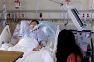 A person connected to a ventilator while lying in a hospital bed. 