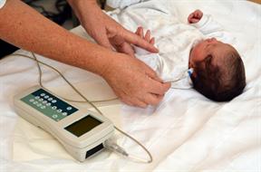 A newborn having their hearing tested.