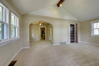 Living room vaulted ceilings, multiple windows, shades installed.