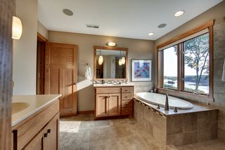 Oval soaking tub, separate "snail style" shower (doorless). Separate linen space and storage.