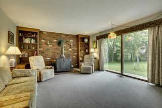 Family room off of foyer. Large double glass door. Original stove/fireplace and brick provide character and warmth. Fantastic view of backyard and into Lake Windsor.