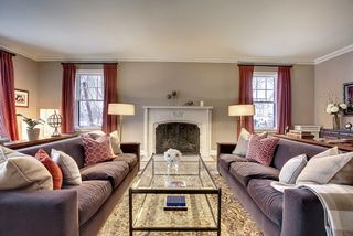 The Formal Living Room features a Stone Fireplace, Hardwood Floors and Original Crown Moldings.