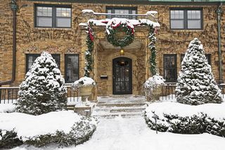 The gracious Entry Approach to the home features heated aggregate sidewalks, Bluestone Terraces and custom iron fence.