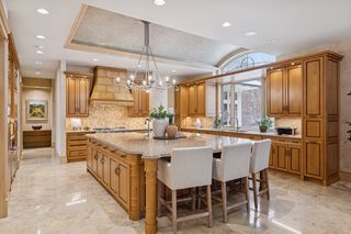 Kitchen is filled with natural light and has an abundance of different lighting for bright work spaces and soft ambiance.