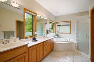 Tiled owner's bath with dual sinks, soaking tub, separate shower and private water closet.