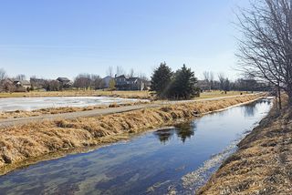 A stream separates the yard and the community walking trail