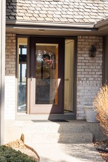 Front door with double side light and covered entry.