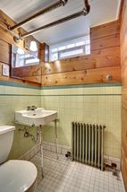 Bead board ceiling, pine walls, ceramic floor, ventilating glass block window. 