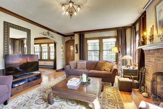 The Living Room features a Brick Fireplace, Crown Moldings & Original Light Fixtures.