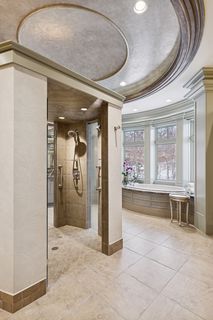 Shower sports two entrances and two shower heads with side sprays.