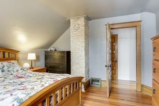 master bedroom with exposed brick and refinished hardwood floors