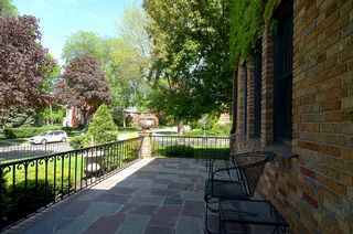The gracious ivy covered front entry features Stone Columns & Bluestone Terrace!