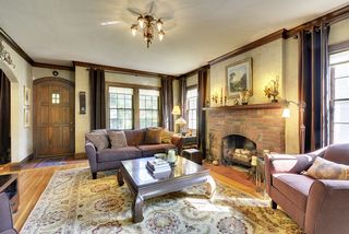 The gracious Living Room features a Wood Burning Fireplace & Original Light Fixtures.