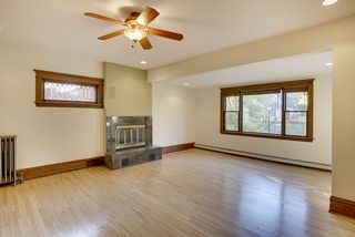 The Light-Filled Living Room features Hardwood Floors, Leaded Glass Window & Fireplace...